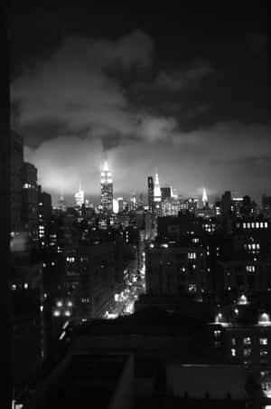 紐約天際線的黑白夜景，發光的建築物和雲層。