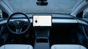 Tesla Model S 車內：簡潔儀表板、大屏幕、環境燈光。