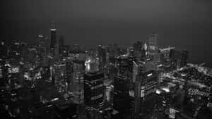 密集城市的夜晚航拍視圖，有發光的摩天大樓和街道。 — 極簡美學 壁紙