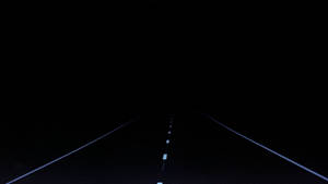夜間黑暗的道路，發光的車道標記延伸至遠方 — 迷幻暗黑風格 壁紙