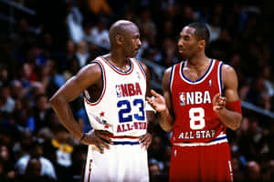 米高佐敦和高比拜仁穿著NBA全明星制服在球場上交談。 — 科比· Bryant 壁紙