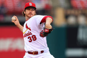 身穿 Cardinals 球衣的棒球投手在比賽中投球。