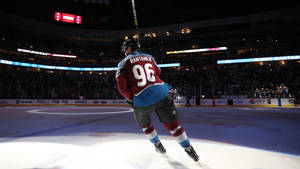 冰球運動員Rantanen 96號在場館燈光下在冰上滑行。