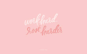 在柔軟的粉紅色背景上，以優雅草書呈現的勵志名言 work hard rosé harder。