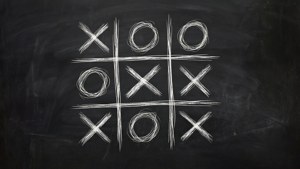 在黑板上用粉筆畫的井字遊戲，帶有X和O。