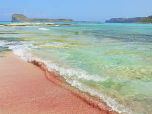 粉紅沙灘上碧綠海浪在清澈藍天下翻滾。 — 海灘日落 壁紙