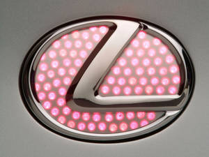 銀色車頭蓋上以粉紅色 LED 照亮的 Lexus 標誌。