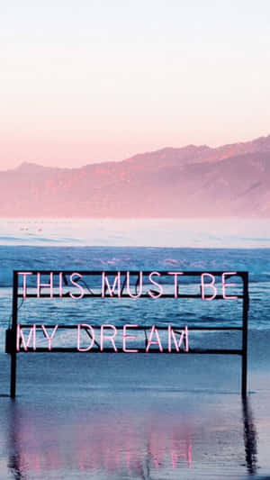 日落時分海中的「THIS MUST BE MY DREAM」霓虹燈牌。 — 淺粉紅色美學動圖 壁紙