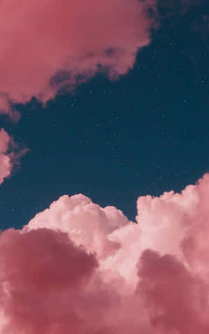 粉紅雲朵漂浮在繁星點點的藍綠色天空上，黃昏時分。