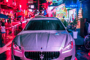 銀色汽車停在潮濕的霓虹燈街道上，夜晚有行人。