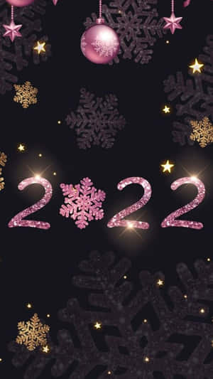 節日粉紅色和金色雪花和星星，帶有閃閃發光的 2022 數字，在黑色背景上。