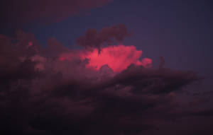 深紫色暮色天空中閃耀的粉紅色雲朵