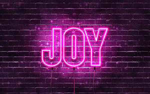 夜間潮濕磚牆上寫有 JOY 的粉紅色霓虹燈牌。 — 淺粉紅色美學動圖 壁紙