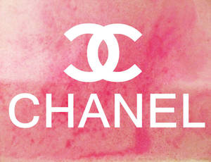 粉紅色水彩背景上的白色Chanel標誌和品牌名稱。