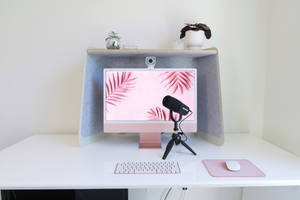 極簡家居辦公室，配備玫瑰金 iMac、麥克風和白色桌面配件。