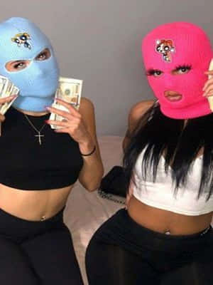 兩名戴著飛天小女警頭套的蒙面女子在床上手持現金。