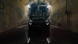 黑色林寶堅尼 Aventador 在濕滑混凝土隧道中，配以工業照明。