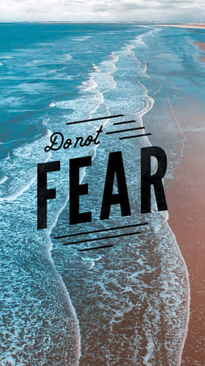 在藍綠色波浪和微紅色沙灘上的勵志文字「Do not FEAR」。 — 經文美感 壁紙