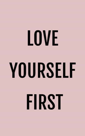 簡約勵志名言「love yourself first」以黑色文字顯示在粉紅色背景上 — Galaxy Tab S9 FE 壁紙