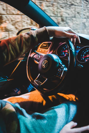 夜間駕駛福士汽車的人，車內溫暖照明，窗外磚牆景觀。