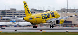 黃色精神航空飛機從機場跑道起飛。
