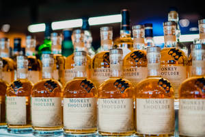 明亮燈光下，酒吧架上的一排排 Monkey Shoulder 威士忌酒瓶。