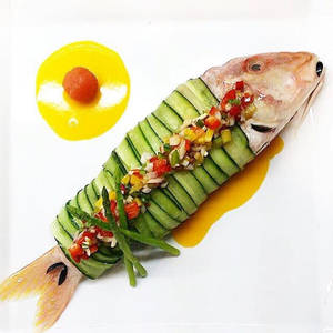 以青瓜包裹的精緻魚料理，配上色彩繽紛的蔬菜配料。
