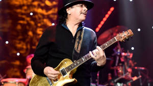 Carlos Santana 在現場音樂會中於舞台上演奏電結他。