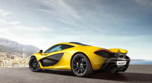 黃色McLaren跑車在懸崖上俯瞰沿海城市。