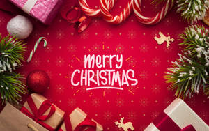 聖誕裝飾包括禮物、拐杖糖和松樹枝在紅色背景上，帶有Merry Christmas文字。