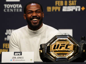 Jon Jones 在UFC記者會上帶著冠軍腰帶微笑。