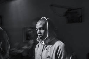 穿著連帽衫的男人在昏暗的房間裡低頭，對話中 — 黑白 壁紙