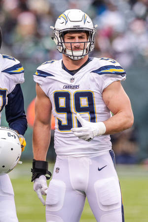 NFL美式足球員身穿電光人球衣號碼99，在日落時分的球場上。