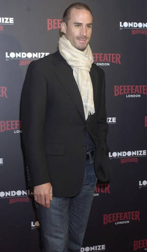 男子在Beefeater London活動中穿著黑色西裝外套和奶油色圍巾。 — 荷里活 GIF 壁紙