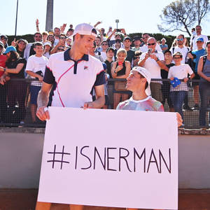 兩位網球選手舉著 #ISNERMAN 標語牌，身後有歡呼的粉絲。 — 網球 壁紙