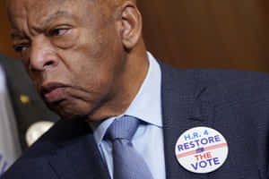 身穿西裝的男子佩戴 'Restore the Vote' 徽章，神情憂慮。 — 政治 壁紙