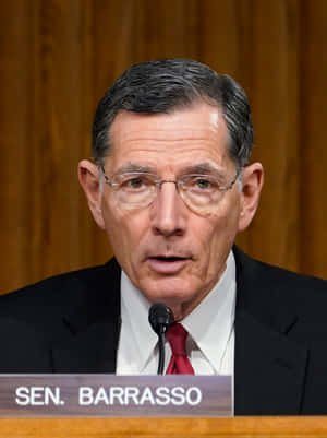 參議員Tom Barrasso在正式聽證會上發言，戴著眼鏡和紅色領帶。