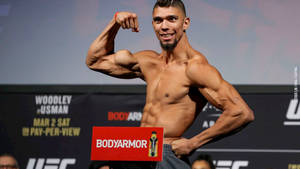UFC拳手在稱重活動中與BodyArmor標誌一起彎曲肱二頭肌。