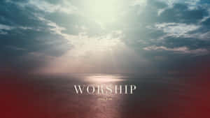 陽光穿過暴風雲層照耀海洋，帶有 worship 文字。