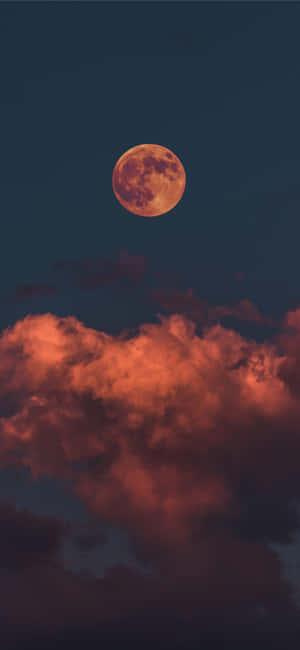 一輪滿月般的橙色月亮照亮了黑暗夜空中的紅色雲層。 — 月色夜空 壁紙
