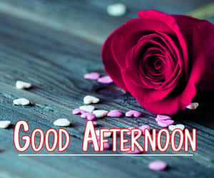 木頭上的紅玫瑰和心形糖果，帶有「GOOD AFTERNOON」文字。