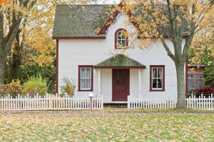秋葉中的白色小屋，紅色門和籬笆