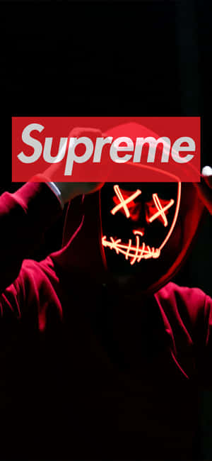穿紅色連帽衫的人手持發光Supreme標誌及恐怖面具。