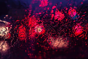 雨滴扭曲了夜間窗戶上鮮豔的紅色和藍色城市燈光。 — 紅色 壁紙