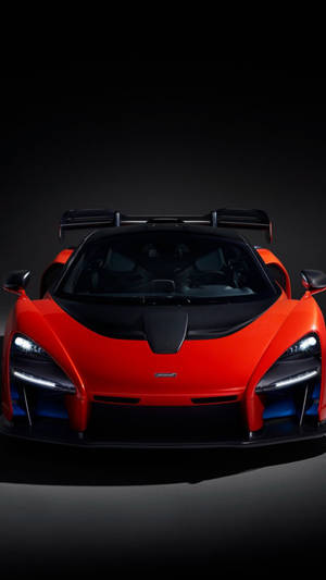 紅色McLaren Senna跑車在深色工作室環境中配備發光的頭燈。