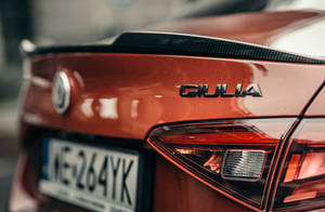 紅色Alfa Romeo Giulia車尾特寫，帶碳纖維尾翼和尾燈。