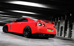 紅色日產GT-R夜間停泊在混凝土天橋下，帶有動態模糊。