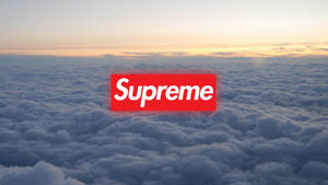 紅色Supreme標誌在日出時漂浮在蓬鬆的雲層之上。