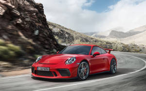 紅色保時捷911 GT3 RS在山路上疾馳，風景模糊。