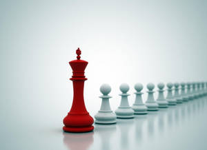 一個紅色國際象棋國王面對一排白色兵卒，在乾淨的反射表面上。